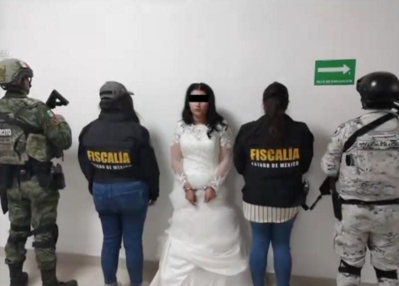 The bride, identified as Nancy N., is seen handcuffed while wearing her wedding dress.
