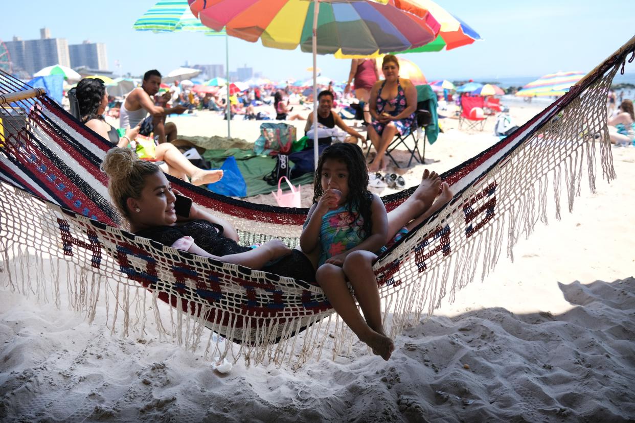 People sit in a hammock as they visit the beach at Coney Island in Brooklyn on July 19, 2020 in New York City. 