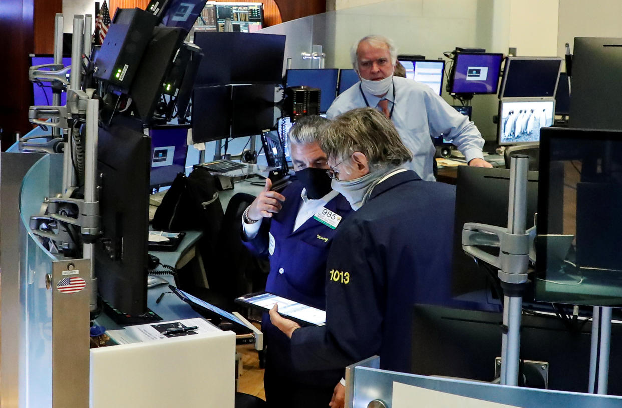 Traders wearing masks work, on the first day of in person trading since the closure during the outbreak of the coronavirus disease (COVID-19) on the floor at the New York Stock Exchange (NYSE) in New York, U.S., May 26, 2020. REUTERS/Brendan McDermid