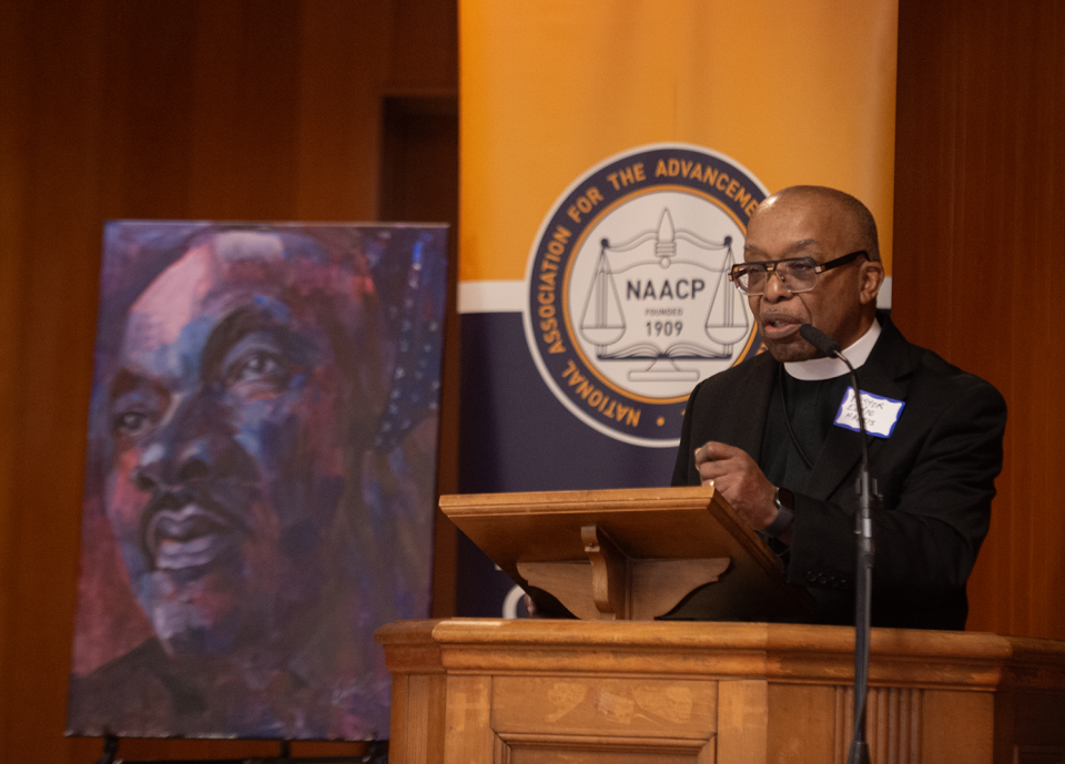 Senior pastor Eddie Harris of Upper Room Ministries speaks at the annual Martin Luther King Jr. Prayer Breakfast on Saturday. On stage with the pastor is a portrait of Martin Luther King Jr. that Harris painted.