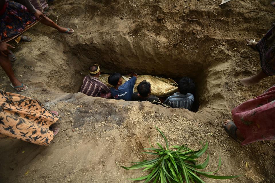 <p>People burry an earthquake victim during a burial ceremony at Tanjung, in northern Lombok on West Nusa Tenggara province on Aug. 10, 2018. (Photo: Sonny Tumelaka/AFP/Getty Images) </p>