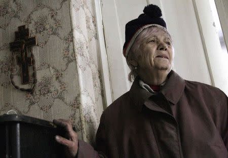 A woman reacts as she walks through a house damaged in what locals said was recent shelling, in the suburbs of Donetsk January 30, 2015. REUTERS/Alexander Ermochenko