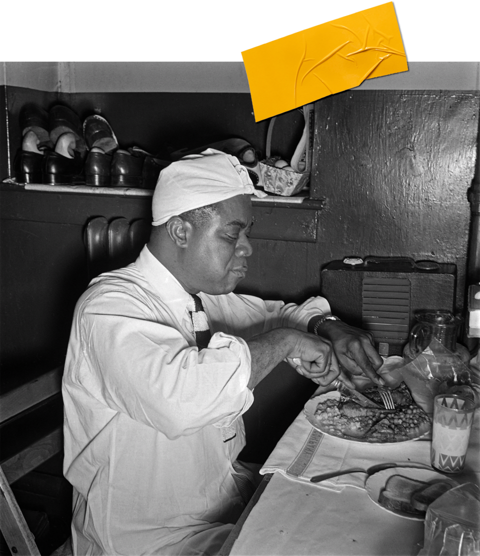 Louis Armstrong enjoying a plate of legumes. (ERIC SCHWAB / Getty Images)