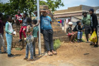 Residents stand in the streets of Lawley, South Africa, during a visit of local government officials for the launch of the Vooma vaccination program against COVID-19 Friday Dec. 3, 2021. South Africa has accelerated its vaccination campaign a week after the discovery of the omicron variant of the coronavirus. (AP Photo/Jerome Delay)