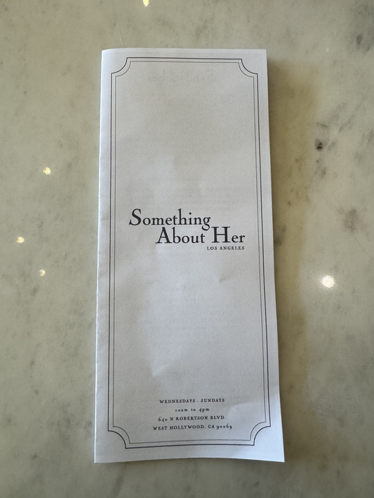 Menu from "Something About Her" in Los Angeles. It includes restaurant hours: Wednesday-Sunday, 12-5 PM, located at 640 N Robertson Blvd, West Hollywood, CA