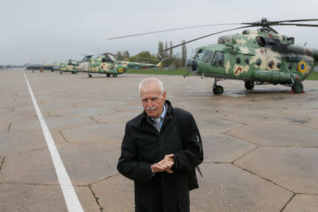 Ukrainian military pilot Mykola Volkozub, who was deployed in a team to fly a helicopter over the reactor to measure the temperature and composition of gases after the accident at the Chernobyl nuclear power plant in 1986, stands near Mi-8 helicopters at a military base in Kiev Region, Ukraine April 24, 2018. REUTERS/Valentyn Ogirenko