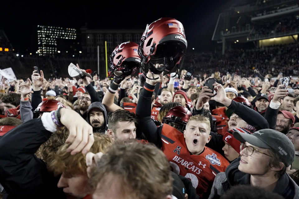 Cincinnati fans and players celebrate after winning the American Athletic Conference championship NCAA college football game against Houston Saturday, Dec. 4, 2021, in Cincinnati. (AP Photo/Jeff Dean)