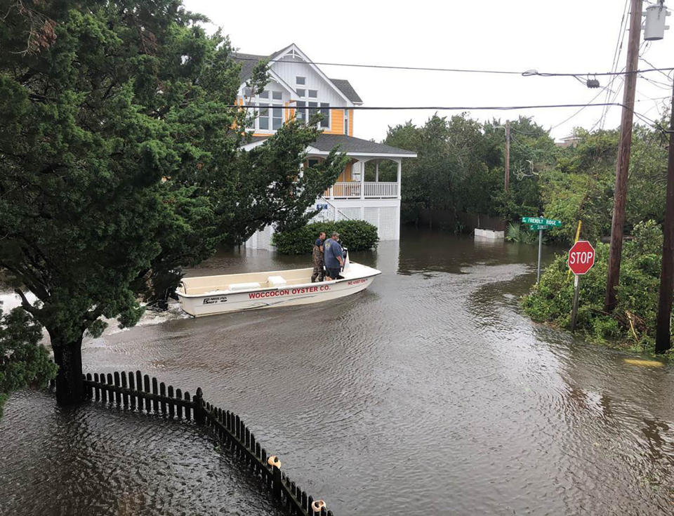 Ocracoke Volunteer Fire Department chief Albert O’Neal, in blue shirt, boats down Sunset Drive on his way to seek out islanders stranded in their flooded homes in the aftermath of Hurricane. Dorian Friday, Sept. 6, 2019 on Ocracoke Island, N.C. (Connie Leinbach/Ocracoke Observer via AP)