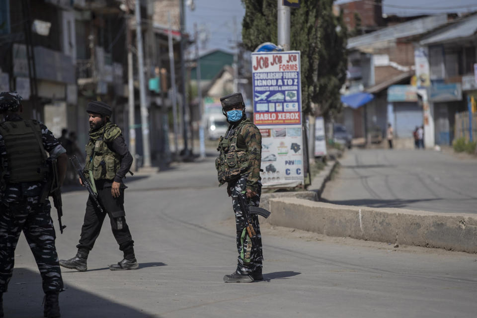 Indian paramilitary soldiers stand guard near the site of a shootout at Sopore, 55 kilometers (34 miles) north of Srinagar, Indian controlled Kashmir, Saturday, June 12, 2021. Two civilians and two police officials were killed in an armed clash in Indian-controlled Kashmir on Saturday, police said, triggering anti-India protests who accused the police of targeting the civilians. (AP Photo/Mukhtar Khan)