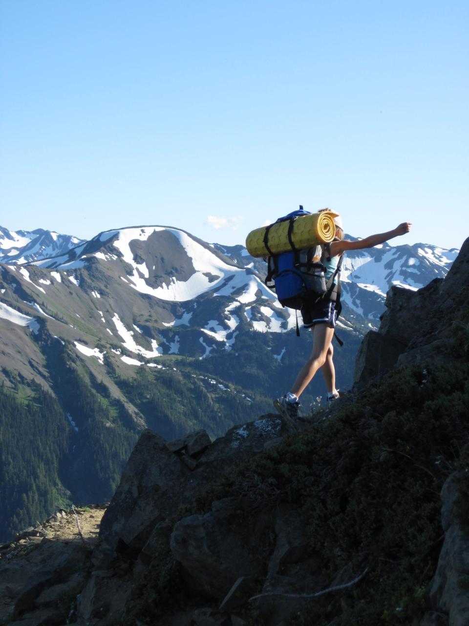 A backpacker hikes up a mountain at Olympic National Park.