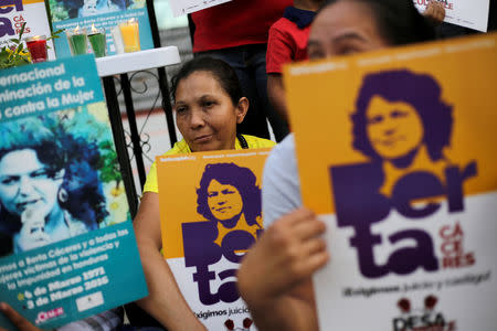 Demonstrators hold signs outside a court during the trial of the men charged with the murder of indigenous environmental activist Berta Caceres, in Tegucigalpa, Honduras November 29, 2018. REUTERS/Jorge Cabrera