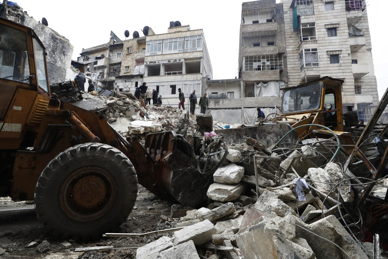 Syrian Civil Defense workers and security forces search through the wreckage of collapsed buildings, in Aleppo, Syria, Monday, Feb. 6, 2023. A powerful earthquake rocked wide swaths of Turkey and neighboring Syria on Monday, toppling hundreds of buildings and killing and injuring thousands of people. (AP Photo/Omar Sanadiki)
