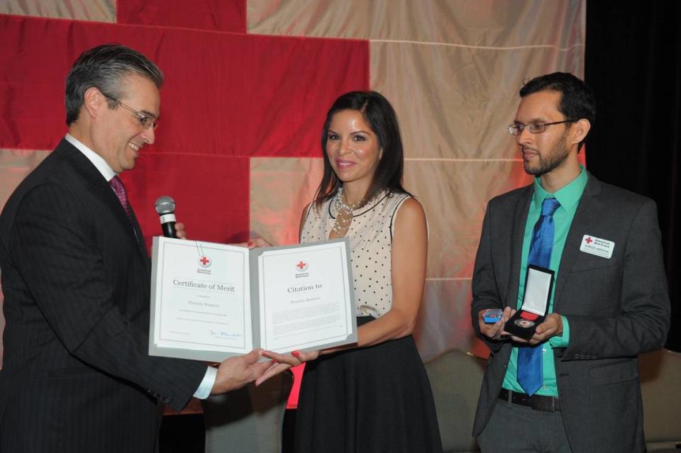 Pamela Rauseo recibe un homenaje durante la 21ª entrega anual de los prestigiosos premios Sara Hopkins Woodruff Spectrum Awards For Women, que la Cruz Roja Americana de la región sur de la Florida celebró en el Ritz-Carlton Key Biscayne, en abril de 2014. Rauseo, que fue noticia en todo el mundo cuando, en una concurrida autopista de Miami, realizó la RCP aprendida a través de la Cruz Roja para salvar a su sobrino Sebastián de la Cruz, de 5 meses, recibió el máximo honor durante la ceremonia del almuerzo. Alfred Sánchez, director ejecutivo de la Cruz Roja Americana del Gran Miami y Capítulo de los Cayo le entregó la Medalla Presidencial y el Certificado al Mérito. Miami Herald Archives