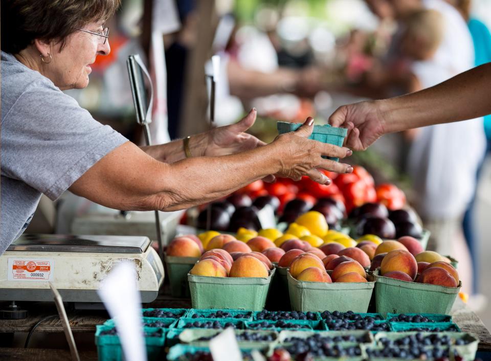 In this 2014 file photo. Joann Hosbrough helps a customer at the Crump Family Gardens booth at the Peoria Farmers Market at Metro Centre.