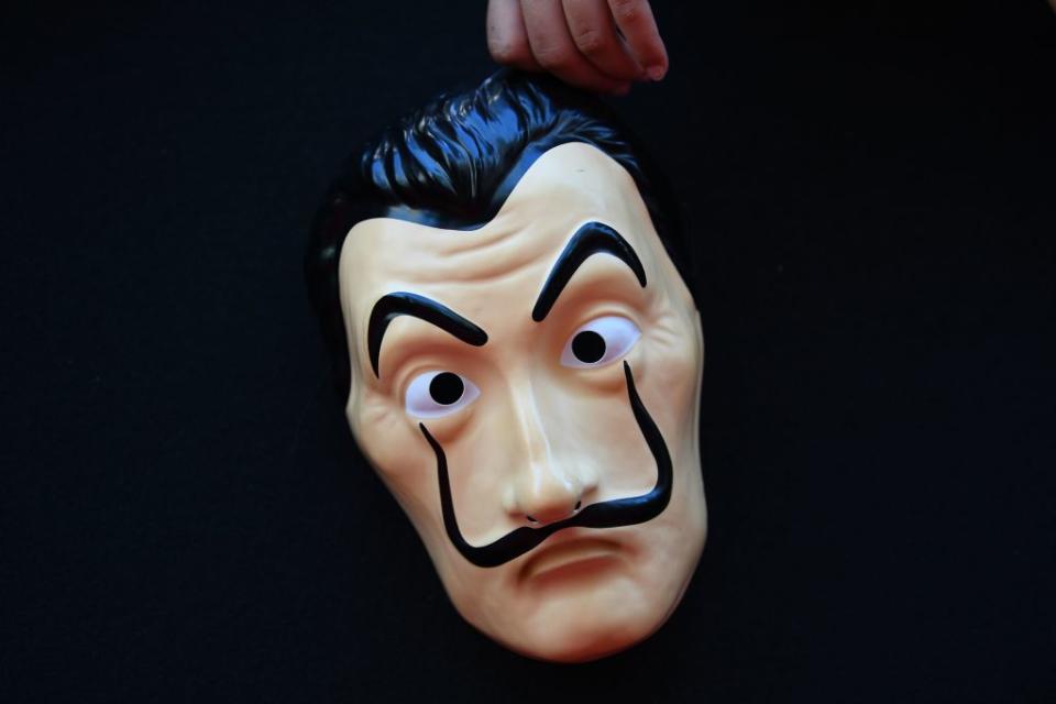 Indissociables de la série, les masques de Dali portés par les braqueurs ont fait polémique en 2019. La fondation Gala-Dali qui contrôle l'image du célèbre peintre, a en effet envisagé à l'époque des poursuites judiciaires contre la série qui à ses yeux utilisait l'image de l'artiste espagnol à mauvais escient. La raison pour laquelle Salvador Dali avait été choisi tient, selon les auteurs de <em>La Casa de Papel</em>, à sa personnalité anticonformiste. Ces derniers estiment au contraire que la série contribue à apporter une visibilité supplémentaire à l'œuvre de Dali. (©Gabriel Bouys/AFP via Getty Images)