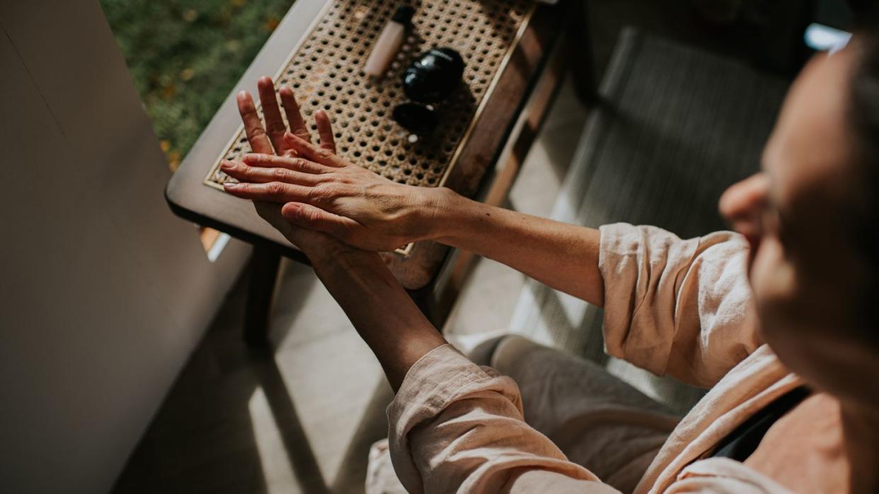 a woman moisturises her hands