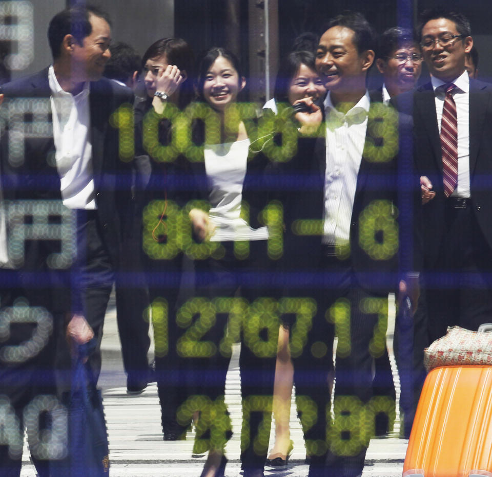 People are reflected on the electronic board of a securities firm in Tokyo, Monday, June 18, 2012. Asian stock markets climbed Monday after elections in Greece eased fears of global financial turmoil, but analysts warned that the economic crisis shaking the 17 nations in the euro common currency was far from over. Tokyo's benchmark Nikkei 225 index was up 1.8 percent at 8,721.41. (AP Photo/Koji Sasahara)