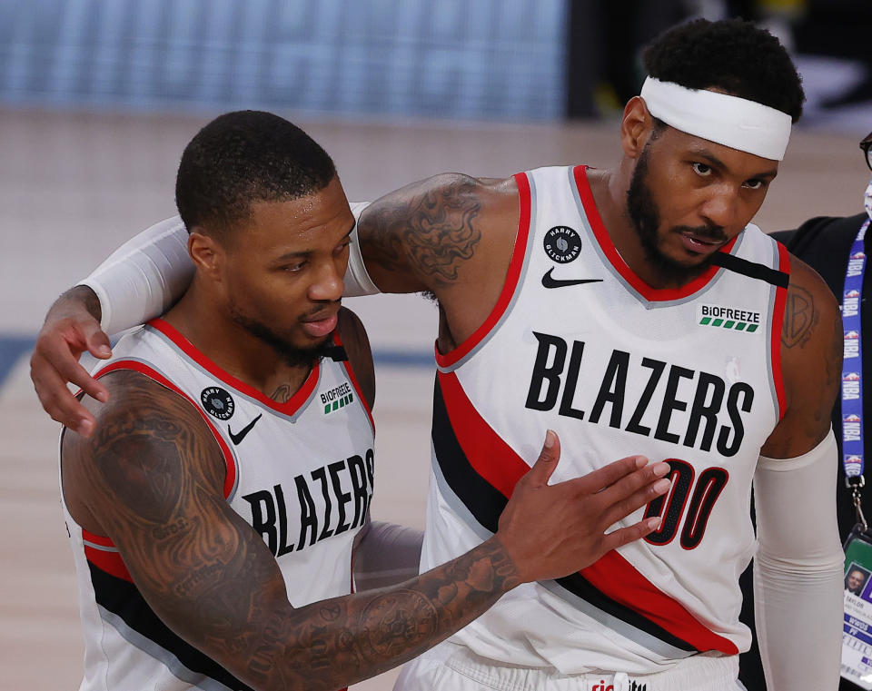 Portland Trail Blazers' Carmelo Anthony, right, and Damian Lillard celebrate the team's win over the Philadelphia 76ers in an NBA basketball game Sunday, Aug. 9, 2020, in Lake Buena Vista, Fla. (Kevin C. Cox/Pool Photo via AP)