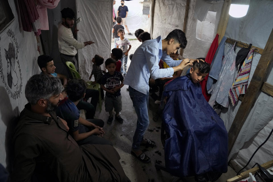 Syrian children get haircuts ahead of the Eid al-Adha celebrations at a makeshift barbershop inside a tent at a refugee camp in the town of Bar Elias, in the Bekaa Valley, Lebanon, July 7, 2022. The Lebanese government’s plan to start deporting Syrian refugees has sent waves of fear through vulnerable refugee communities already struggling to survive in their host country. Many refugees say being forced to return to the war shattered country would be a death sentence. (AP Photo/Bilal Hussein)