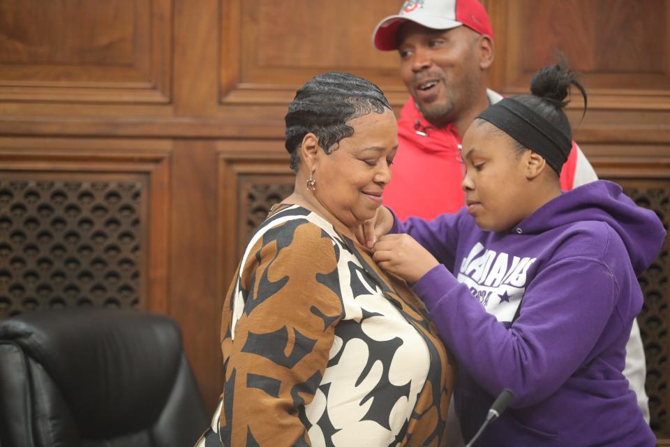 New Ward 4 Akron City Councilwoman Jan Davis is pinned by her granddaughter Diamond Clark and son Brandon Davis after being sworn in Monday by Judge Kani Hightower.