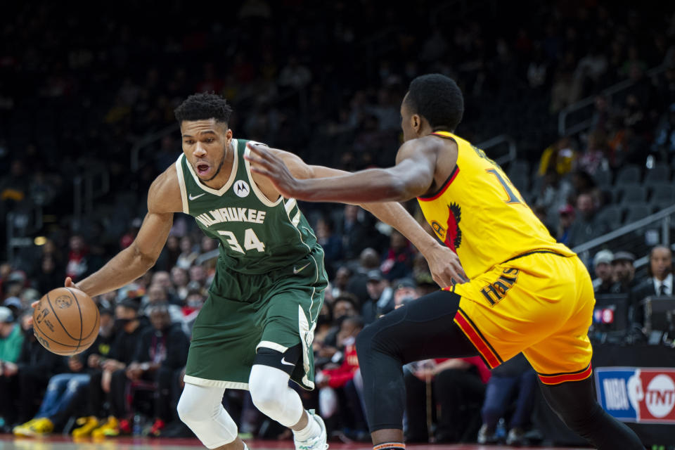 Milwaukee Bucks forward Giannis Antetokounmpo (34) dribbles past Atlanta Hawks forward Onyeka Okongwu (17) during the first half of an NBA basketball game Monday, Jan. 17, 2022, in Atlanta. (AP Photo/Hakim Wright Sr.)