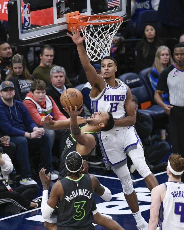 Minnesota Timberwolves forward Kyle Anderson is fouled by Sacramento Kings forward Keegan Murray (13) in front of Timberwolves forward Jaden McDaniels (3) during the second half of an NBA basketball game Saturday, Jan. 28, 2023, in Minneapolis. The Timberwolves won 117-110. (AP Photo/Craig Lassig)