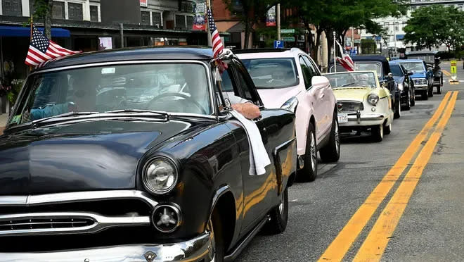 Classic cars of various make and model make their way through downtown Natick during an informal Fourth of July classic car tour in 2020. The tour travled down the path of Natick's traditional Fourth of July parade, which was canceled that year due to the pandemic.