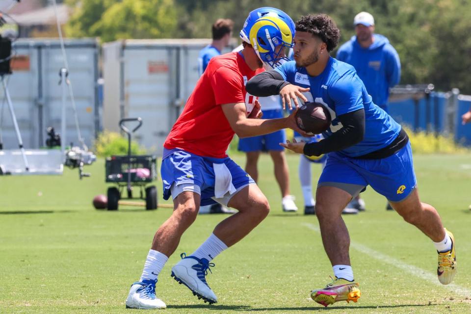 Rams rookie running back Blake Corum takes a handoff from quarterback Matthew Stafford during practice.