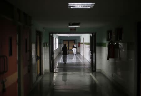 Hospital staff members walk through an empty corridor inside Janakpuri Super Speciality Hospital in New Delhi January 19, 2015. REUTERS/Adnan Abidi