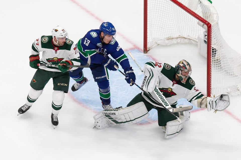 Minnesota Wild goaltender Alex Stalock (32) makes a save against Vancouver Canucks' Bo Horvat (53) as Wild's Brad Hunt (77) defends during the second period of an NHL hockey playoff game in Edmonton, Alberta, Tuesday, Aug. 4, 2020. (Codie McLachlan/The Canadian Press via AP)