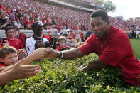 FILE - In this Sept. 11, 2021 file photo, former Georgia running back and Republican candidate for US Senate Herschel Walker greets fans before a college football game between UAB and in Atlanta. The rewards of an early Donald Trump endorsement will be on display Saturday, Sept. 25 in Georgia. A three-man ticket of candidates he’s backing in 2022 Republican primaries for statewide office will take the stage with him. (AP Photo/John Bazemore)