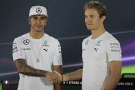 Mercedes Formula One driver Nico Rosberg (R) of Germany shakes hands with Mercedes Formula One driver Lewis Hamilton of Britain before a news conference at the Yas Marina circuit before the start of the Abu Dhabi Grand Prix November 20, 2014. REUTERS/Caren Firouz