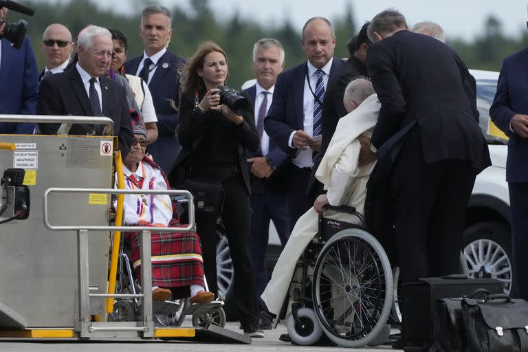 Ayudan al papa Francisco a subirse a una silla de ruedas a su llegada al aeropuerto de Quebec, Canadá, el miércoles 27 de julio de 2022