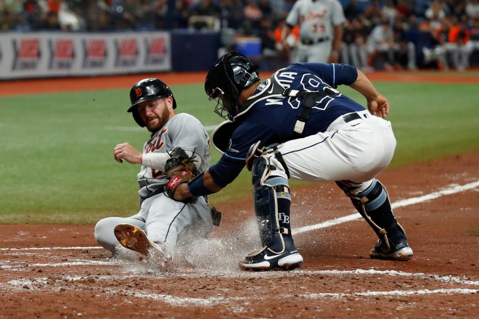 Detroit Tigers' Robbie Grossman, left, beats the tag of Tampa Bay Rays catcher Francisco Mejia while sliding safely home during the third inning of a baseball game Friday, Sept. 17, 2021, in St. Petersburg, Fla.
