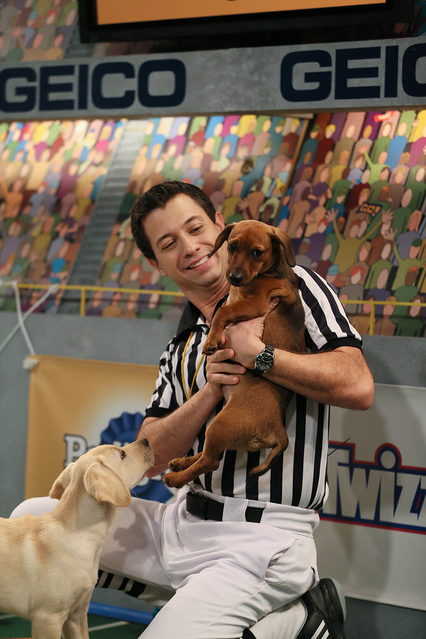 THE PUPPY BOWL X, referee Dan Schachner holding dachshund puppy, (aired Feb. 2, 2014), 2014. photo: Damian Strohmeyer / © Animal Planet/Discovery Communications / Courtesy: Everett Collection