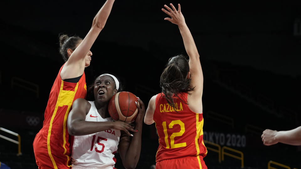 Canada's Laeticia Amihere (15) drives between Spain's Alba Torrens (7), left, and Maria Teresa Cazorla Medina (12) during women's basketball preliminary round game at the 2020 Summer Olympics, Sunday, Aug. 1, 2021, in Saitama, Japan. (AP Photo/Eric Gay)