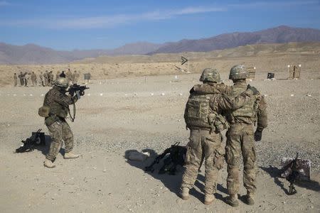 U.S. soldiers from the 3rd Cavalry Regiment watch a member of the Polish military on a shooting range as part of a joint training mission, near forward operating base Gamberi in the Laghman province of Afghanistan in this December 12, 2014 file photo. REUTERS/Lucas Jackson/Files