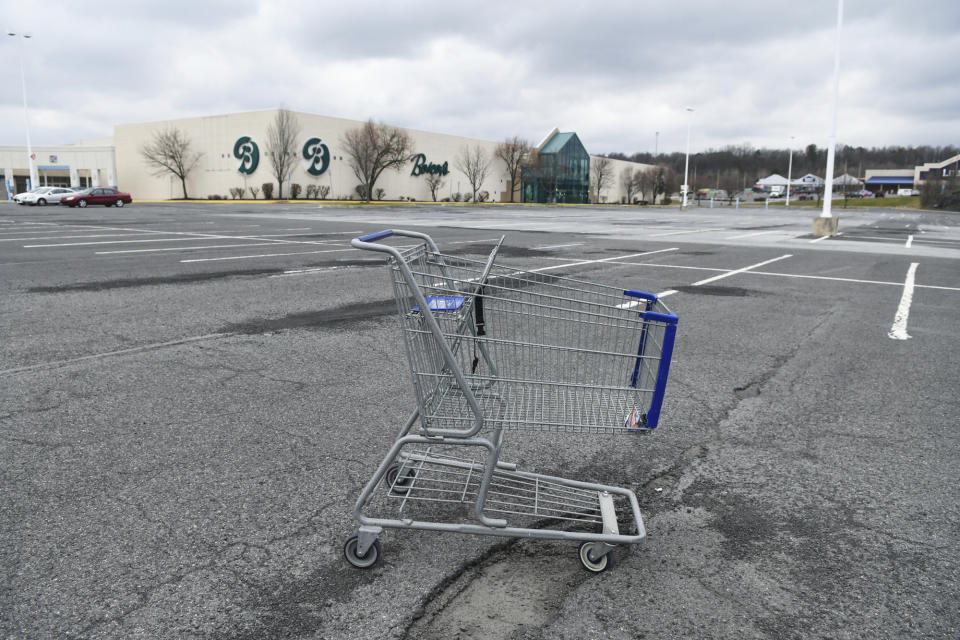 In this Tuesday, March 17, 2020, photo, a lone shopping cart sits in an empty parking lot near a shopping mall closed due to coronavirus concerns in Pottsville, Pa. In Pennsylvania last week, 12,200 people filed for unemployment insurance. In just a single day this week, that number exploded beyond 50,000. In neighboring Ohio, 48,460 people filed for unemployment Sunday and Monday, compared to less than 1,900 over the same period the week before. It’s the same story in state after state, as millions of displaced Americans lose their jobs amid the widening shutdowns to contain the coronavirus. (Jacqueline Dormer/Republican-Herald via AP)