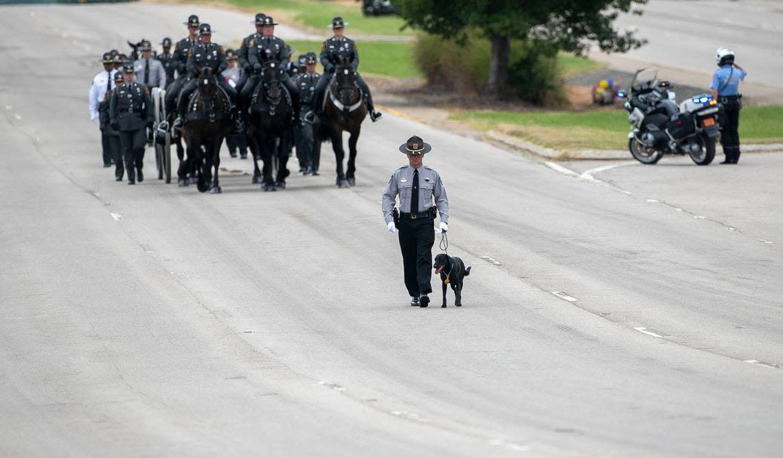 Wake County Deputy Ned Byrds service dog Sasha leads the North Carolina State Highway Patrols Caisson Unit with Byrds casket to his funeral along Glenwood Avenue to Providence Baptist Church on Friday, August 19, 2022 in Raleigh, N.C.