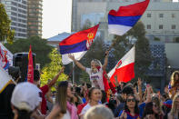 Supporters of Serbia's Novak Djokovic dance and sing outside the Park Hotel, used as an immigration detention hotel where Djokovic is confined in Melbourne, Australia, Sunday, Jan. 9, 2022. After four nights in hotel detention Novak Djokovic will get his day in court on Monday in a controversial immigration case that has polarized opinions in the tennis world and elicited heartfelt support for the star back home in his native Serbia. (AP Photo/Mark Baker)