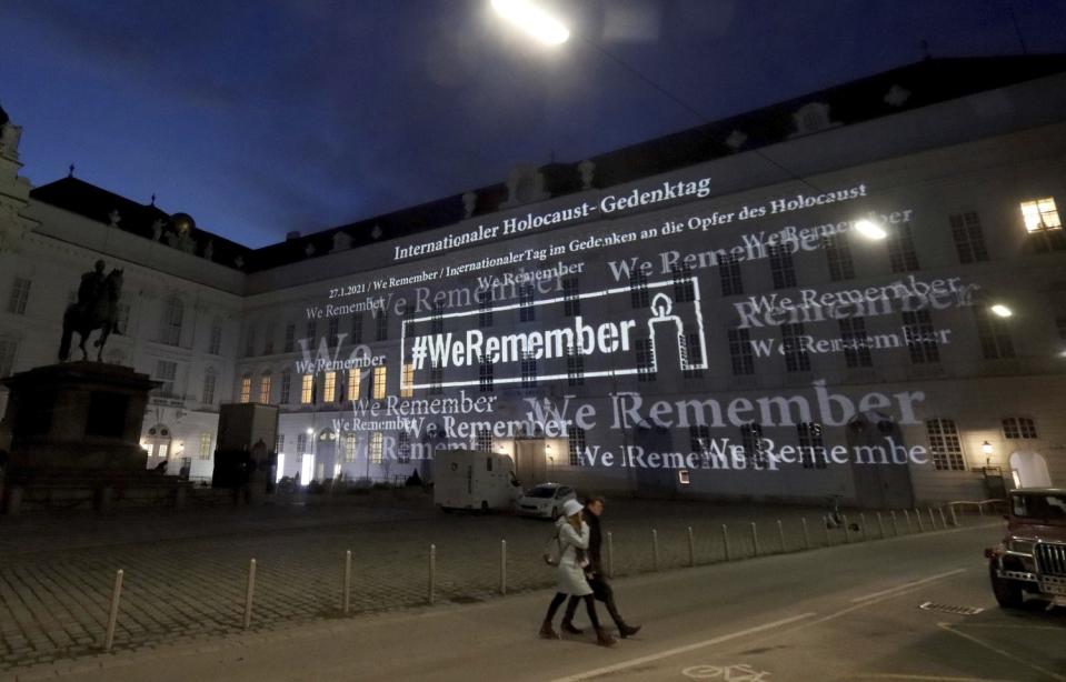 The words '#WeRemember' are displayed at the facade of the Austrian Parliament at the Hofburg