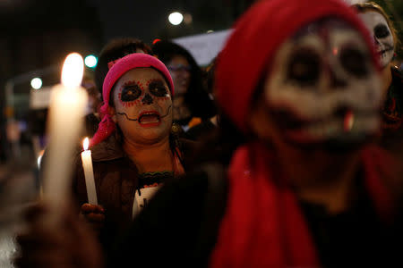 Activists with faces painted to look like the popular Mexican figure "Catrina" take part in a march against femicide during the Day of the Dead in Mexico City, Mexico, November 1, 2017. REUTERS/Carlos Jasso