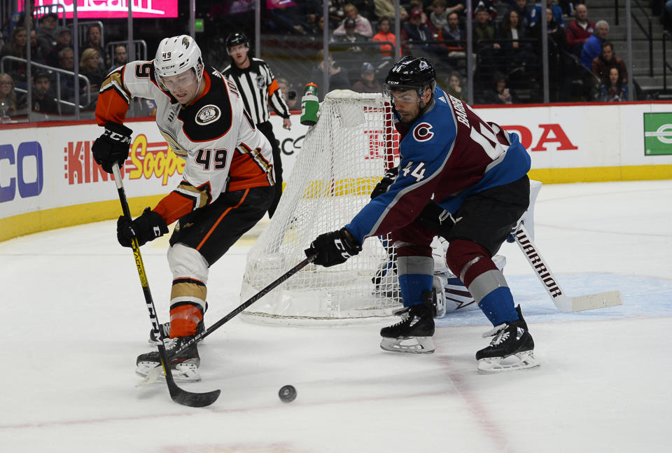 Anaheim Ducks left wing Max Jones (49) backhands the puck as Colorado Avalanche defenseman Mark Barberio (44) pokes at it during the second period of an NHL hockey game Wednesday, March 4, 2020 in Denver. (AP Photo/John Leyba)