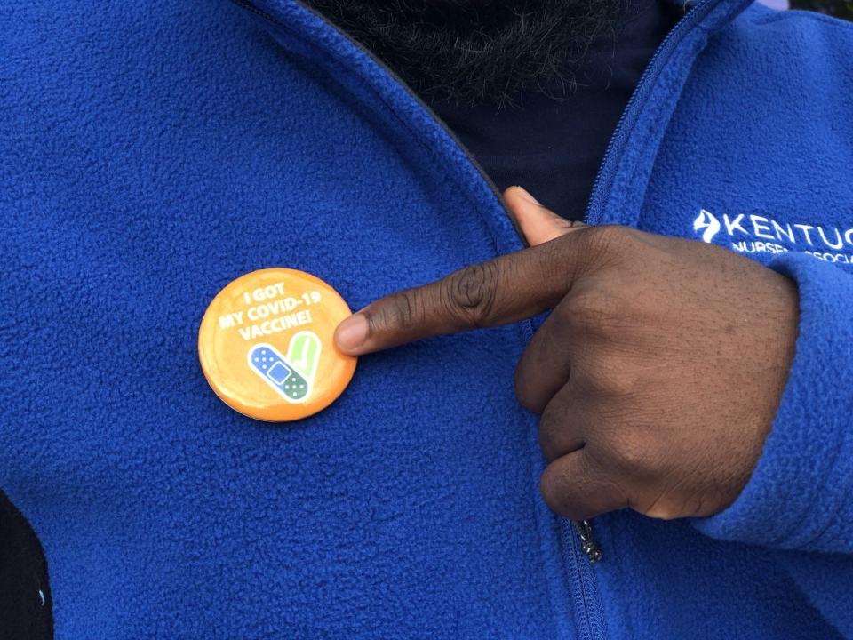 Oluwasegun Abe points to his "I got my COVID-19 vaccine" pin at Shawnee Community Center on Thursday,  Jan. 13, 2022.