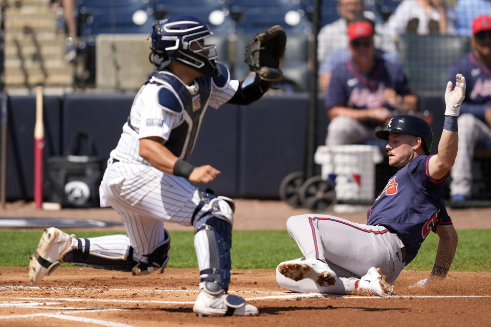 Atlanta Braves' Jarred Kelenic scores as New York Yankees catcher Jose Trevino, left, waits for the throw during the first inning of a spring training baseball game Sunday, March 10, 2024, in Tampa, Fla. (AP Photo/Charlie Neibergall)