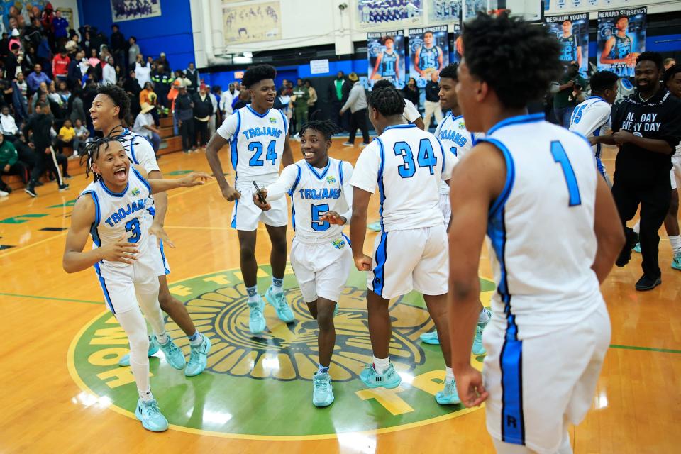 From left, Ribault's Caleb Williams (3), Renard Surrency (23) back, Jamian Jackson (24), and Makai Purkiss (5) celebrate after the game of the 2022-2023 Gateway Conference boys high school basketball tournament final Friday, Jan. 27, 2023 at Jean Ribault High School in Jacksonville, Fla. The Ribault Trojans defeated the Andrew Jackson Tigers 60-55 in overtime. 