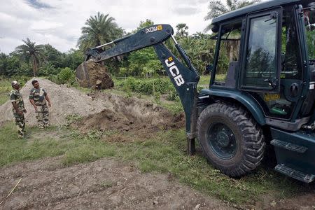 Indian Border Security Force (BSF) soldiers dig a pit to create a natural barrier to prevent the smuggling of cattle near the Indian-Bangladeshi unfenced border in West Bengal, India, June 20, 2015. REUTERS/Rupak De Chowdhuri