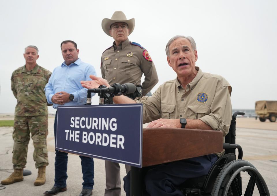 Gov. Greg Abbott speaks at a news conference as Texas Army National Guard troops deploy from Austin-Bergstrom International Airport on Monday to secure the Texas-Mexico border in anticipation of the end of Title 42 later this week. Listening are, from left, Maj. Gen. Thomas Suelzer, Border Czar Mike Banks and Texas Department of Public Safety Director Steve McCraw.