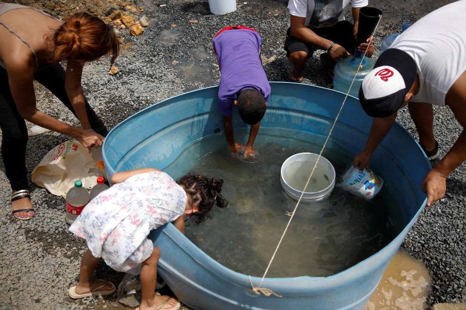 People fill containers with water&nbsp;in an area hit by Hurricane Maria in Canovanas, Puerto Rico, on Tuesday. (Photo: Carlos Garcia Rawlins / Reuters)