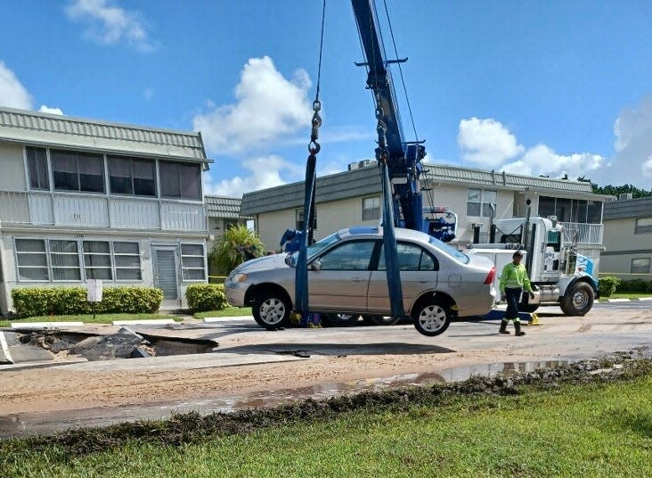 Ingrid Robinson's 2002 Honda Civic is removed from the sinkhole, damaged beyond repair.